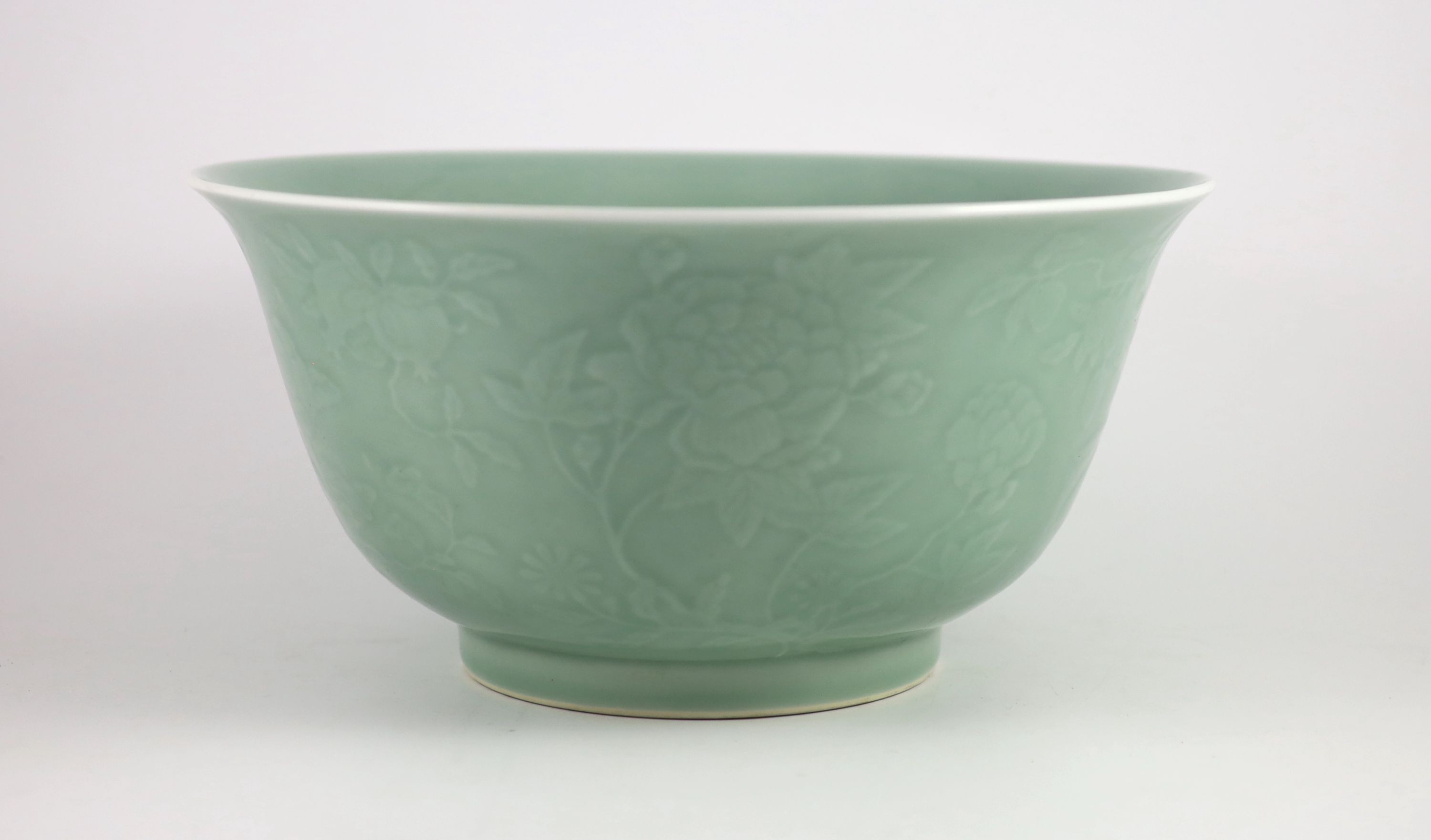 A fine large Chinese moulded celadon-glazed bowl, Qianlong seal mark and of the period (1736-95), Rim 33.6mm diameter, 16.5cm high, foot 16cm diameter